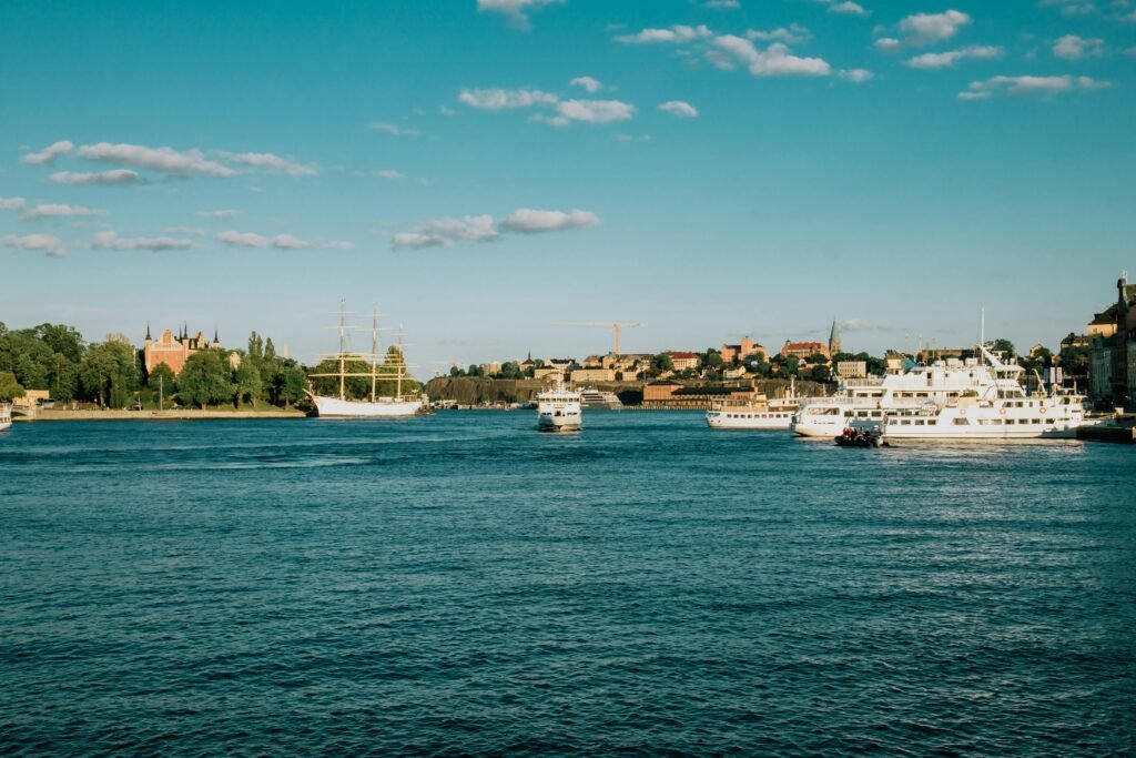 Sunny summer day on the Stockholm waterfront with cruise ships and iconic city skyline in view.